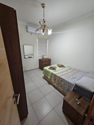 um quarto com uma cama e um lustre em Beautiful two bedroom in center Bugibba em St. Paul's Bay