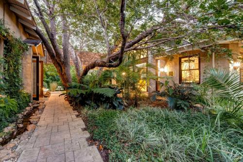 a tree in front of a house with a walkway at Mbano Manor Hotel Victoria Falls in Victoria Falls