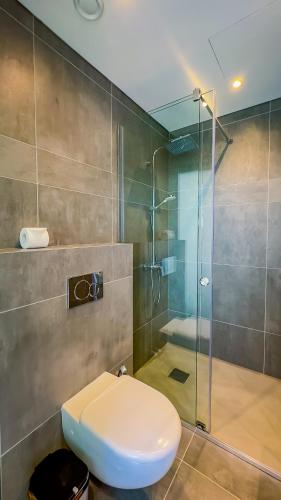 a bathroom with a toilet and a glass shower at Sunrise Beachfront Villas - Villa 1 in Paralimni