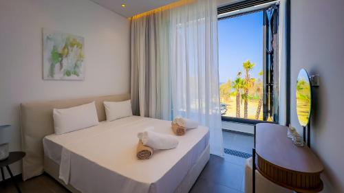 una camera d'albergo con due letti e una grande finestra di Sunrise Beachfront Villas - Villa 1 a Paralimni