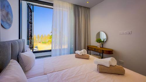a bedroom with a large bed with a large window at Sunrise Beachfront Villas - Villa 1 in Paralimni