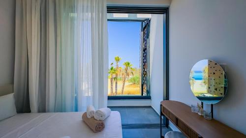 una camera da letto con finestra affacciata sull'oceano di Sunrise Beachfront Villas - Villa 1 a Paralimni