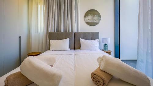 a bedroom with a large bed with white sheets and pillows at Sunrise Beachfront Villas - Villa 1 in Paralimni