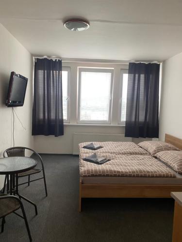 Schlafzimmer mit einem Bett, einem Tisch und einem Fenster in der Unterkunft Penzión Tina in Prešov
