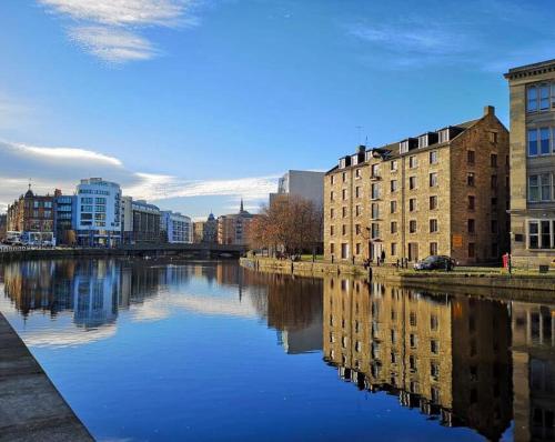 a city with buildings and a river with buildings at Vibrant Apartment at The Shore in Leith in Edinburgh