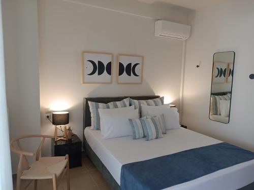 a bedroom with a large white bed with a blue blanket at Amare Luxury Living in Volos