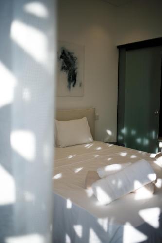 a bedroom with a bed with white sheets at Sunrise Beachfront Villas - Villa 1 in Paralimni