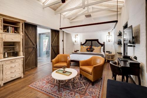 a bedroom with a bed and a table and chairs at Mbano Manor Hotel Victoria Falls in Victoria Falls