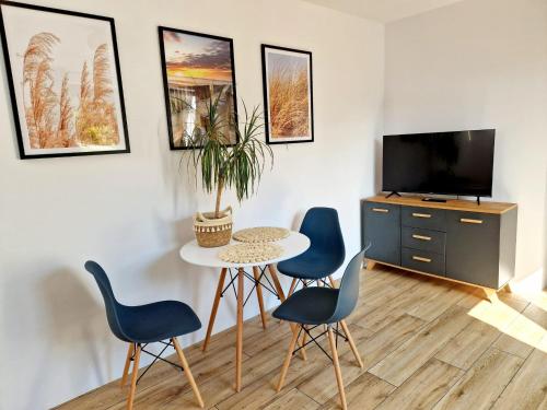 a living room with a table and chairs and a tv at Apartament Amelia1 in Świnoujście