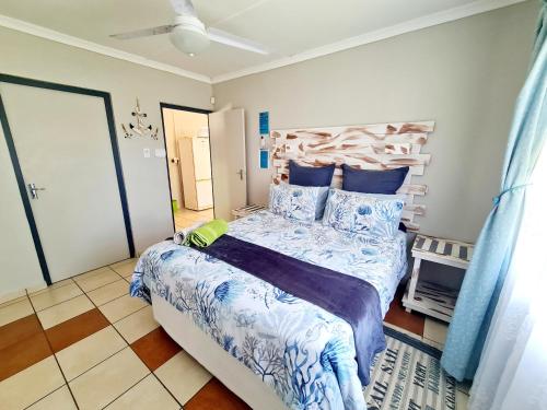 - une chambre dotée d'un grand lit avec des draps bleus et blancs dans l'établissement eagles inn, à Richards Bay