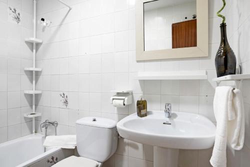 a white bathroom with a toilet and a sink at Casa Soumia in Vejer de la Frontera