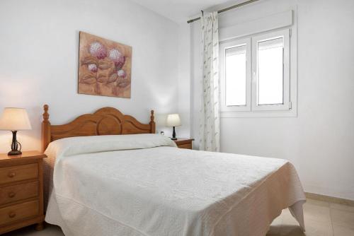 um quarto branco com uma cama e uma janela em Casa Soumia em Vejer de la Frontera