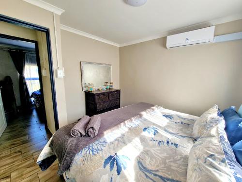 a bedroom with a bed with two slippers on it at eagles inn in Richards Bay