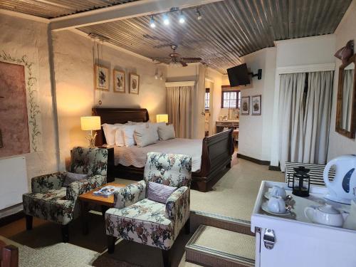 a bedroom with a bed and a couch and a chair at Cleopatra Mountain Farmhouse in Fort Nottingham