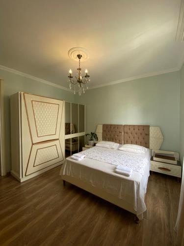 a bedroom with a large bed and a chandelier at Sunny Days in K'obulet'i