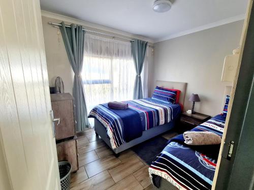 a bedroom with two beds and a window at eagles inn in Richards Bay