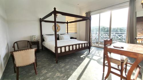 a bedroom with a canopy bed and a balcony at The Sky Imperial Pavoreal Jungle Resort in Kumbhalgarh