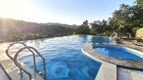 a large swimming pool with aitatingfficient at The Sky Imperial Pavoreal Jungle Resort in Kumbhalgarh