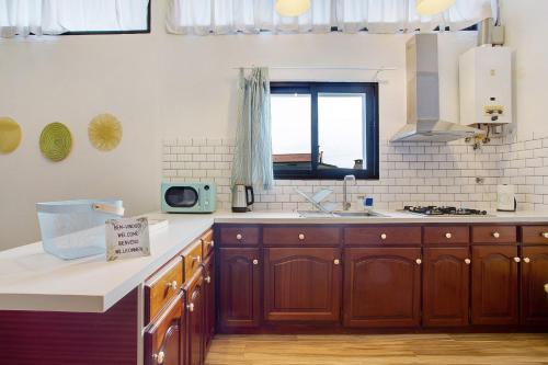 a kitchen with wooden cabinets and a window at Funchal Boa Nova Apartment in Funchal
