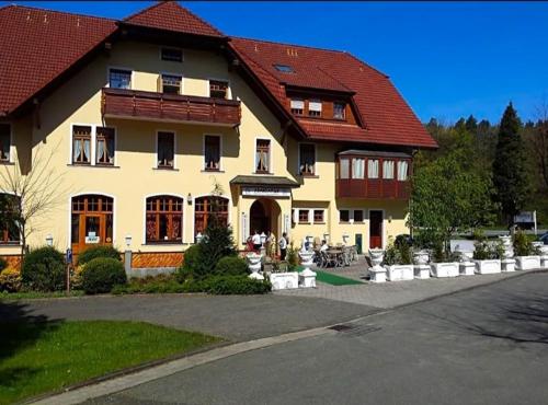 AugustdorfにあるGasthaus Pension DÖRENKRUG - Restaurantの赤い屋根の大きな黄色の建物