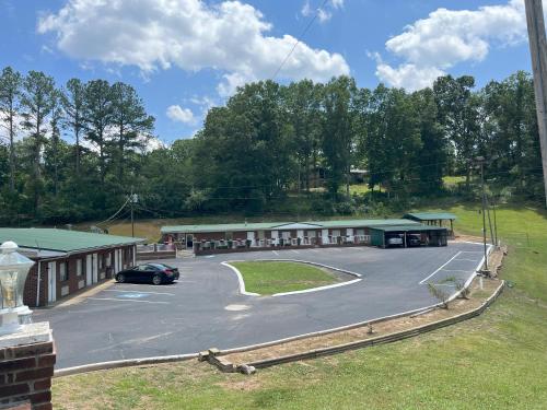 a building with a car parked in a parking lot at Pinetree Inn in Parsons