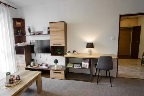 ein Wohnzimmer mit einem Schreibtisch und einem Stuhl in der Unterkunft Apartmán u Klínovce in Kovářská