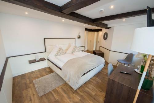 a bedroom with a bed and a desk and a chair at Hotel zum Braunen Hirschen in Bad Driburg