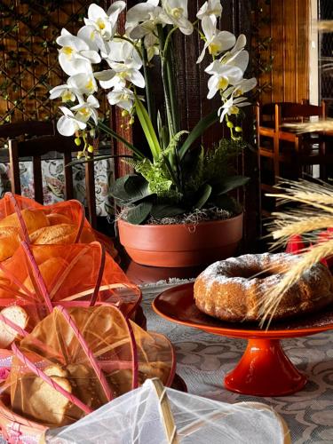 een tafel bedekt met borden met brood en bloemen bij Pousada Três Coqueiros in Praia do Bananal
