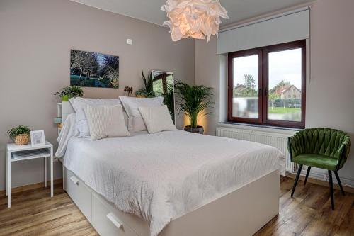 sypialnia z łóżkiem, oknem i żyrandolem w obiekcie BnB Pastel w mieście Dilsen-Stokkem