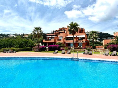 une grande piscine en face d'une maison dans l'établissement Bright apartment in the hills of Elviria, à Malaga