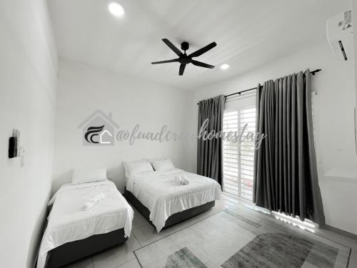 a bedroom with two beds and a ceiling fan at Jitra Fuad's Crew Homestay in Jitra