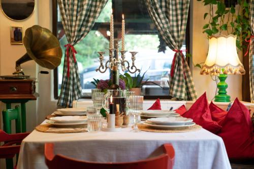 a table with red chairs and a white table cloth at Casa cu Amintiri - Authentic Cozy Cottage in Bran