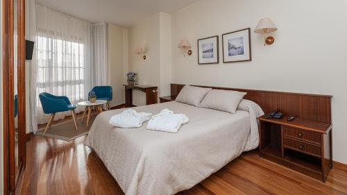 a hotel room with a bed with towels on it at Balneario de Carballo in Carballo