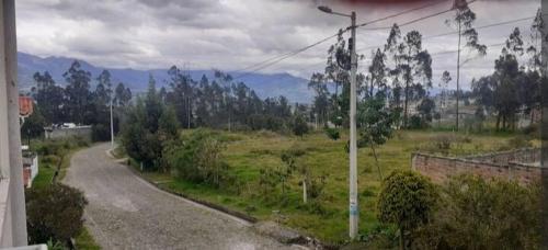 eine Straße auf einem Feld mit Bergen in der Ferne in der Unterkunft Casa campestre en las faldas del Taita Imbabura 3 in Otavalo