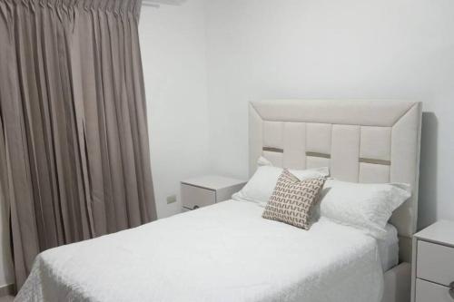 Un pat sau paturi într-o cameră la Penthouse con Piscina en Cotui