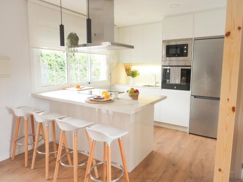 a kitchen with a large white island with bar stools at Casa Rural Horta De Arriba in Porta