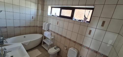 a bathroom with a tub and a toilet and a sink at Madrigal Boutique Rooms in Scheia
