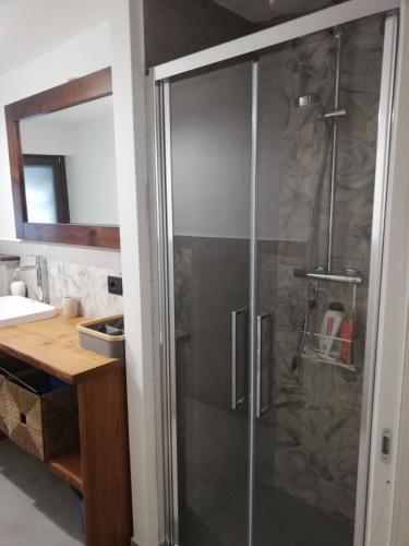 una doccia con una porta in vetro in un bagno di Bardonecchia Apartment a Bardonecchia