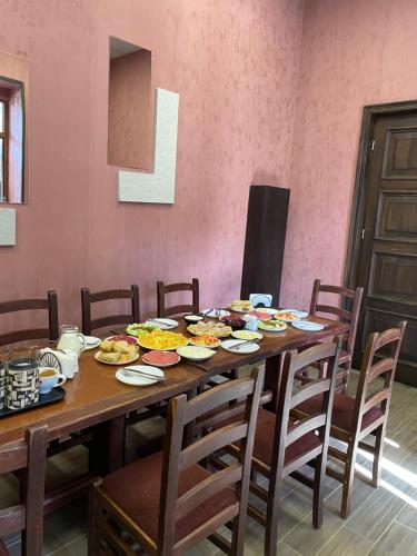 a wooden table with plates of food on it at Hotel Eden in Mestia