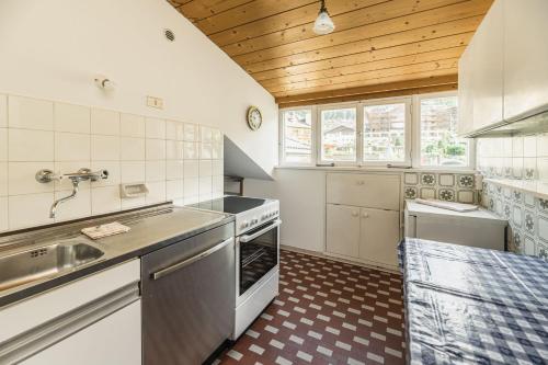 uma cozinha com um lavatório e um fogão em Aquila Dolomites Residence em Ortisei