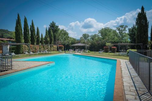 een zwembad in een tuin met bomen bij Mulino Al Suono in Badia Agnano