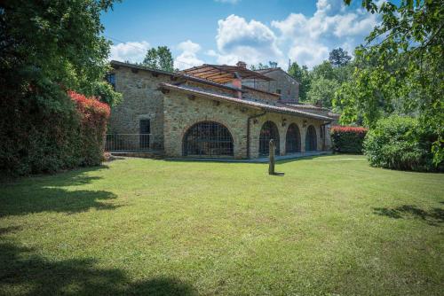 een groot stenen gebouw met een grasveld bij Mulino Al Suono in Badia Agnano