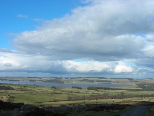 a view of a field with a lake in the distance at The Derwent Arms in Edmondbyers