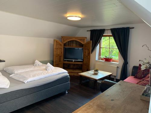 a bedroom with a bed and a tv and a table at Stumbergers Hotel in Cochem