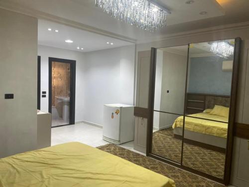 - une chambre avec un lit et un grand miroir dans l'établissement شقة فندقية 3 غرف كمبوند الخمائل, à Kafr Abū ʼumaydah
