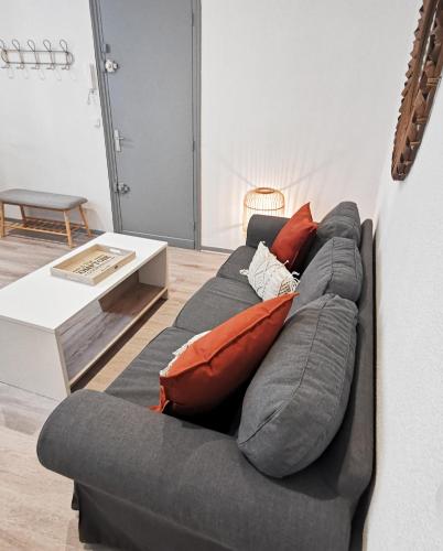 - un canapé gris avec des oreillers dans l'établissement Sur les Pavés du Pont Vieux..., à Carcassonne