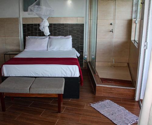a bedroom with a bed and a walk in shower at Toca da Tulipa in Paraty