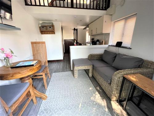 uma sala de estar com um sofá e uma mesa em The Stables - Detached Cottage with Private Garden & Hot Tub em St Austell