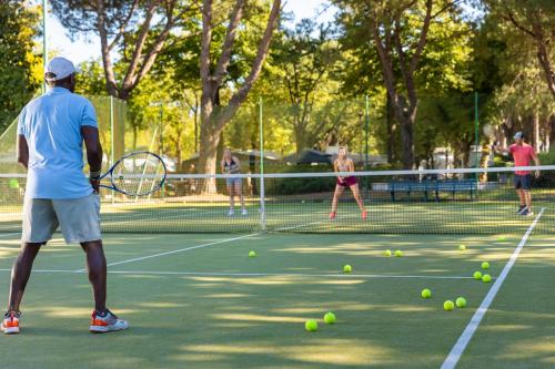 a group of people playing tennis on a tennis court at Camping Village Garden Paradiso in Cavallino-Treporti
