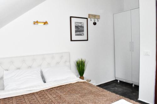 a white bedroom with a large bed with white walls at Hotel Korab Trnica in Trnica